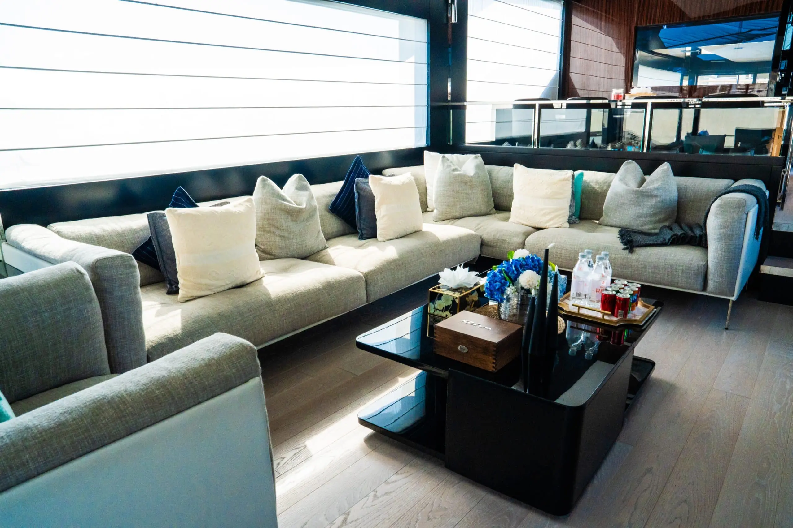 Luxury yacht lounge with sectional sofa, coffee table, and large windows