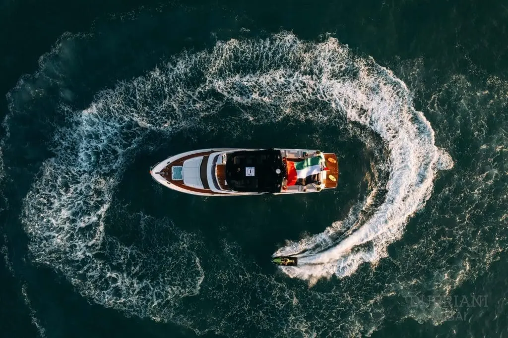 Aerial view of jet tender spinning in circle beside Eclipse yacht in open sea