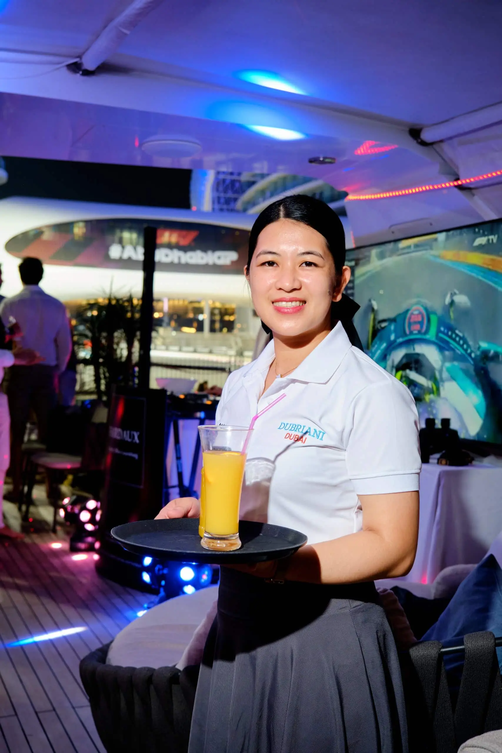 Yacht hostess serving drinks during Abu Dhabi Grand Prix Formula 1 hospitality event