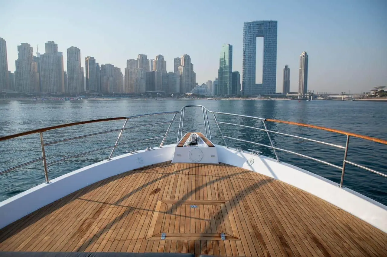 Wooden bow deck of Zenith 64 yacht with Dubai city view