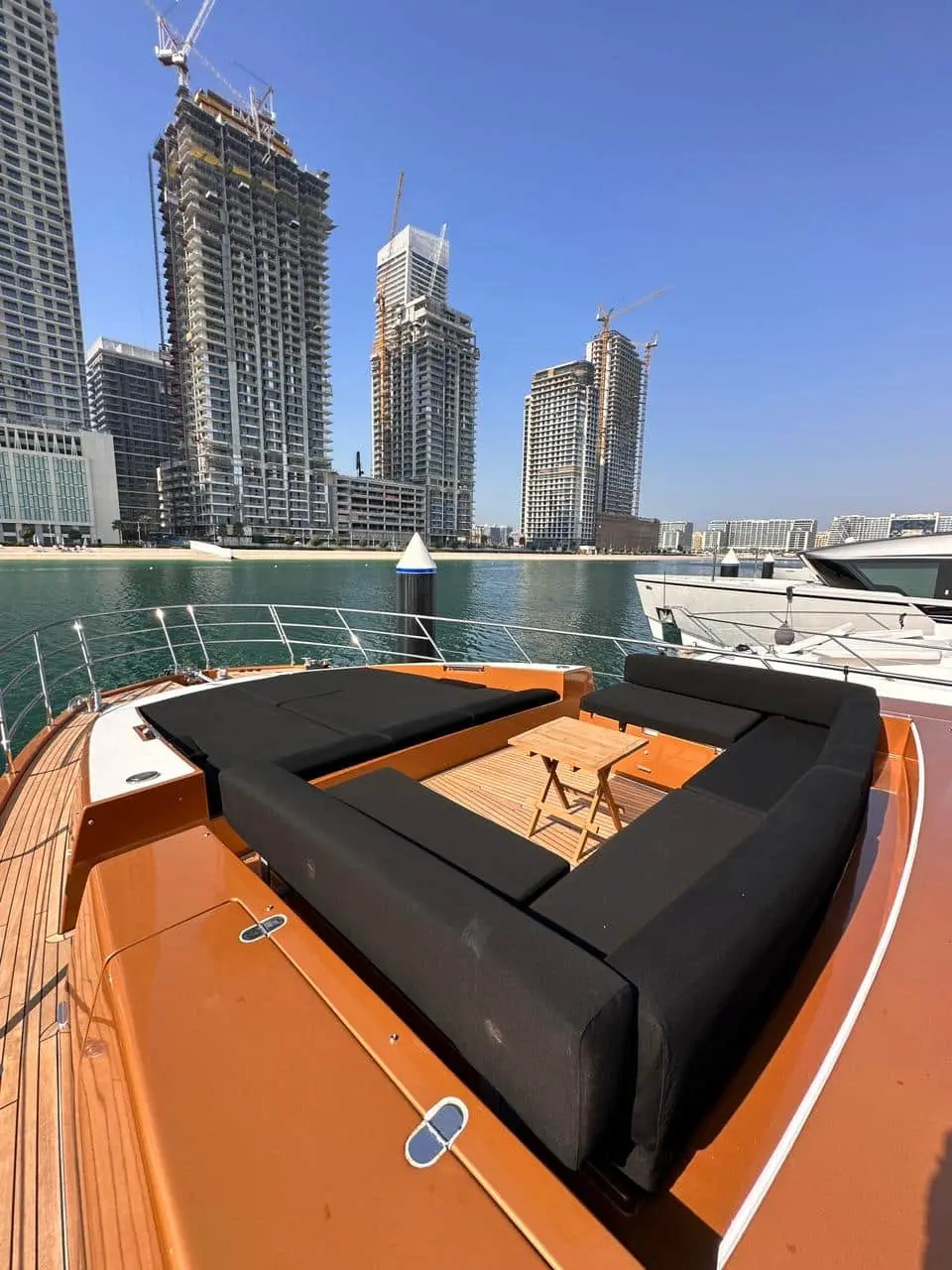 Azimut 77 yacht bow lounge seating with table and city skyline waterfront