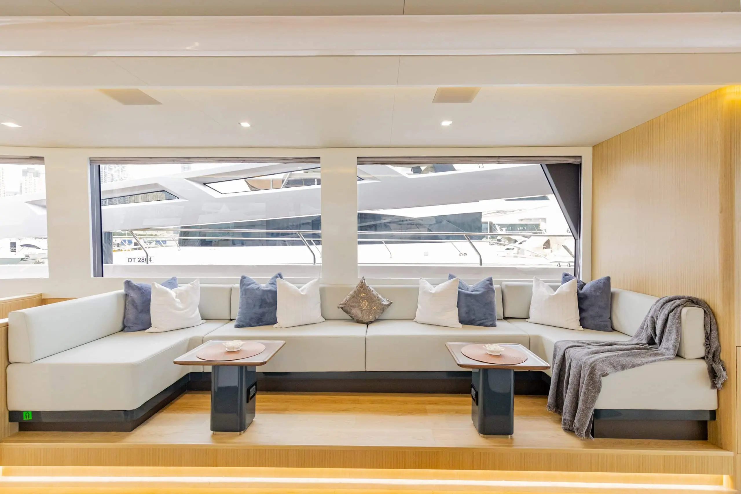 Zirve 72 yacht interior lounge with large panoramic windows and modern sofa seating