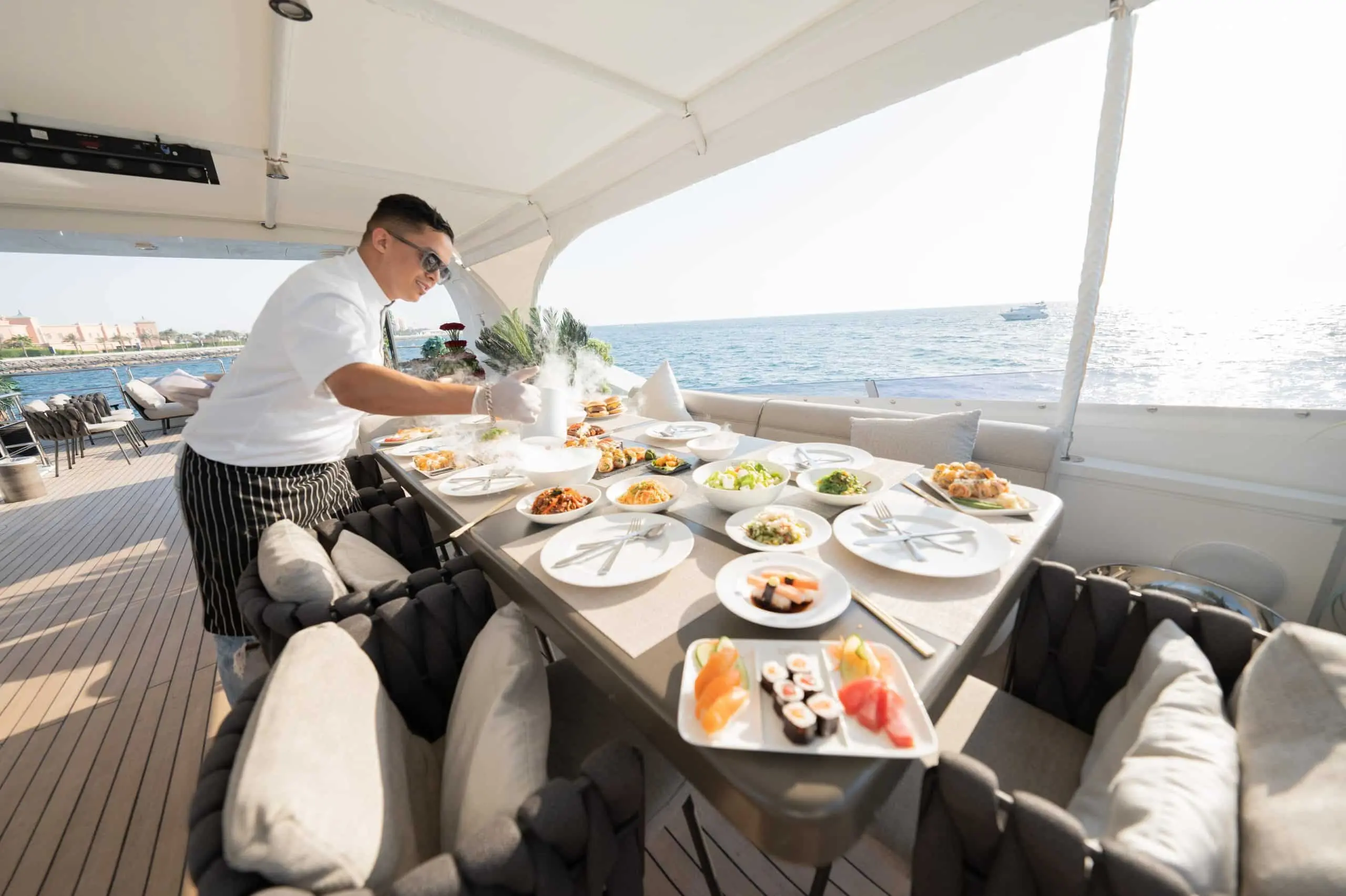 Crew member providing dining service on Tatti 110 yacht