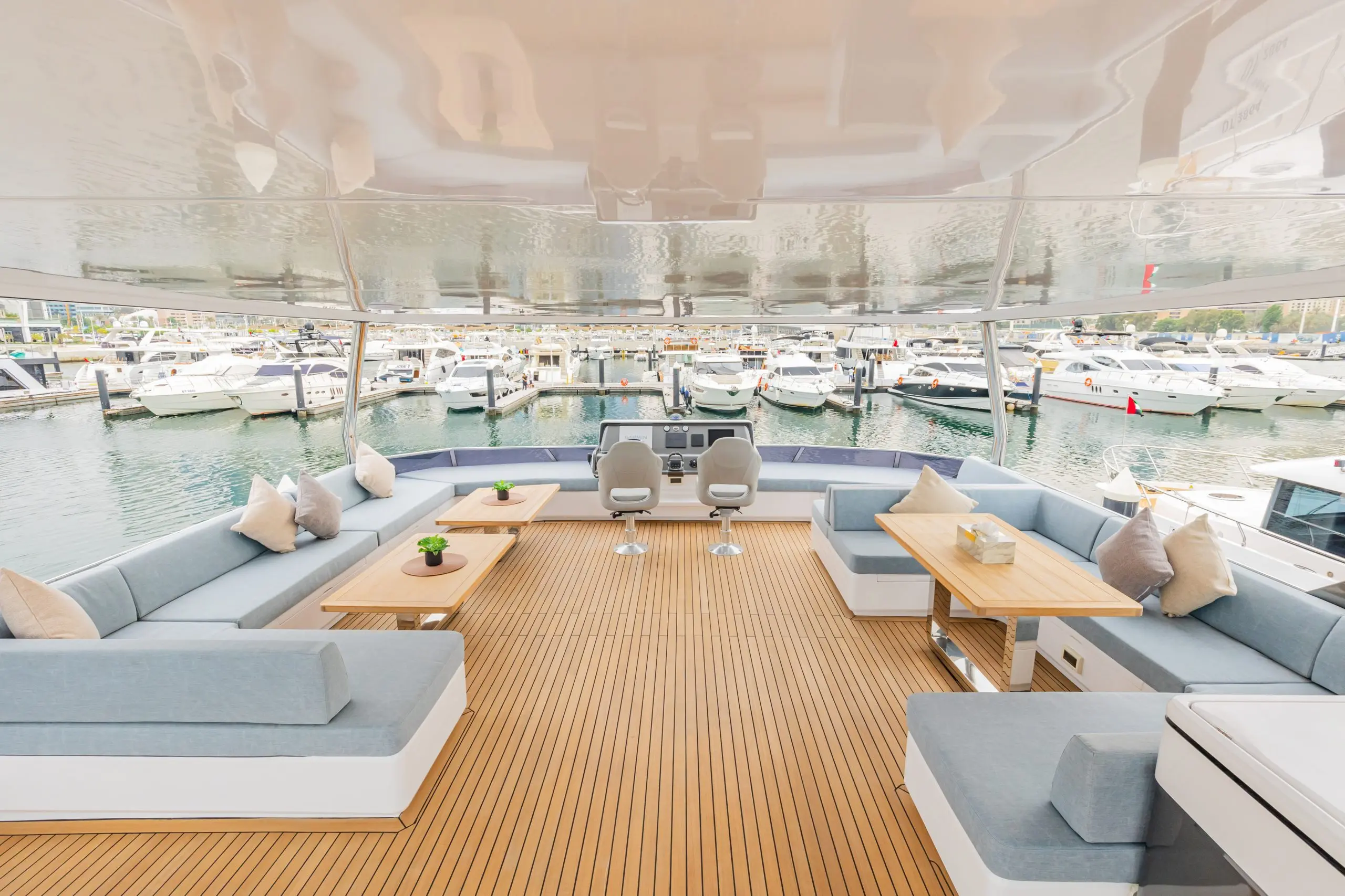 Zirve 72 yacht’s outdoor lounge with cushioned seating and waterfront backdrop