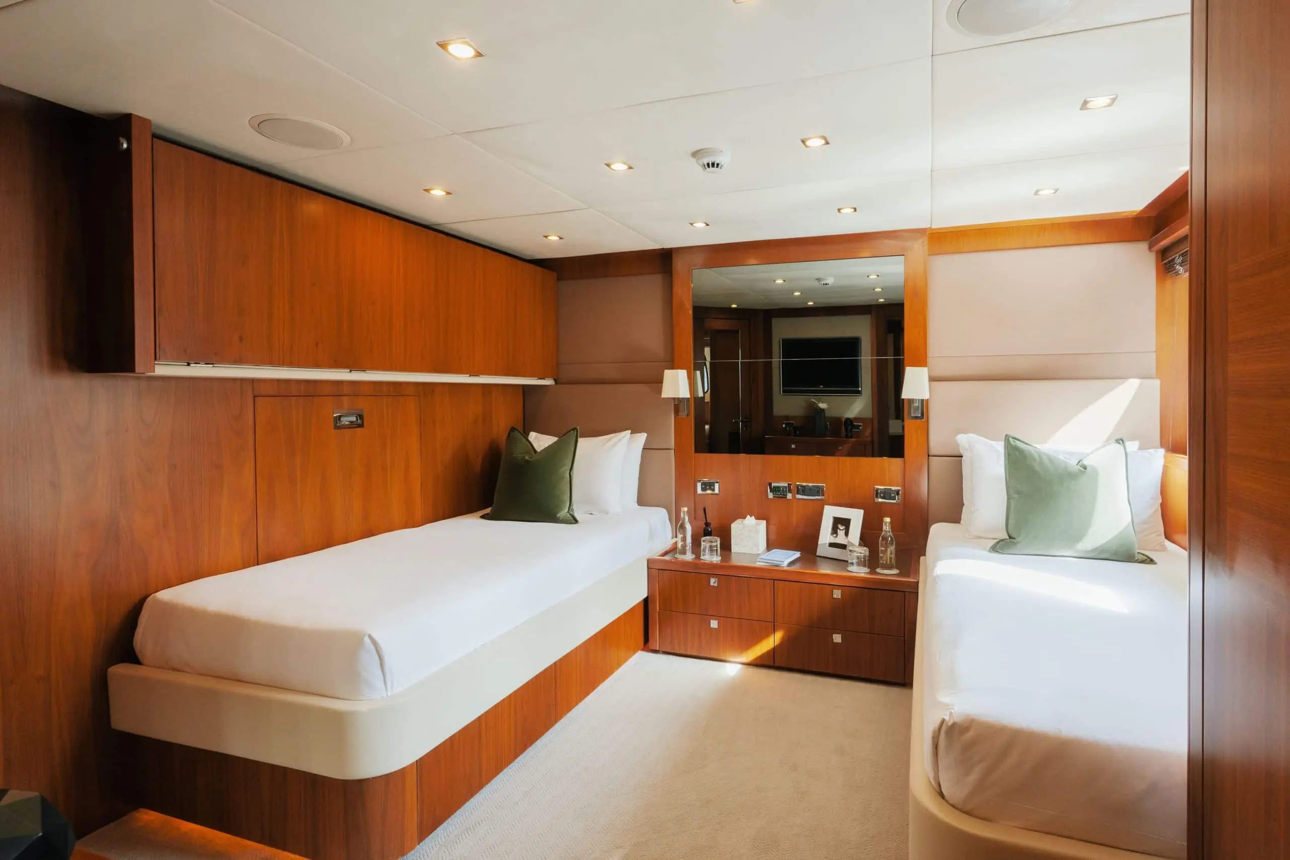 Aurora 130 yacht guest cabin with twin beds and polished wood interior