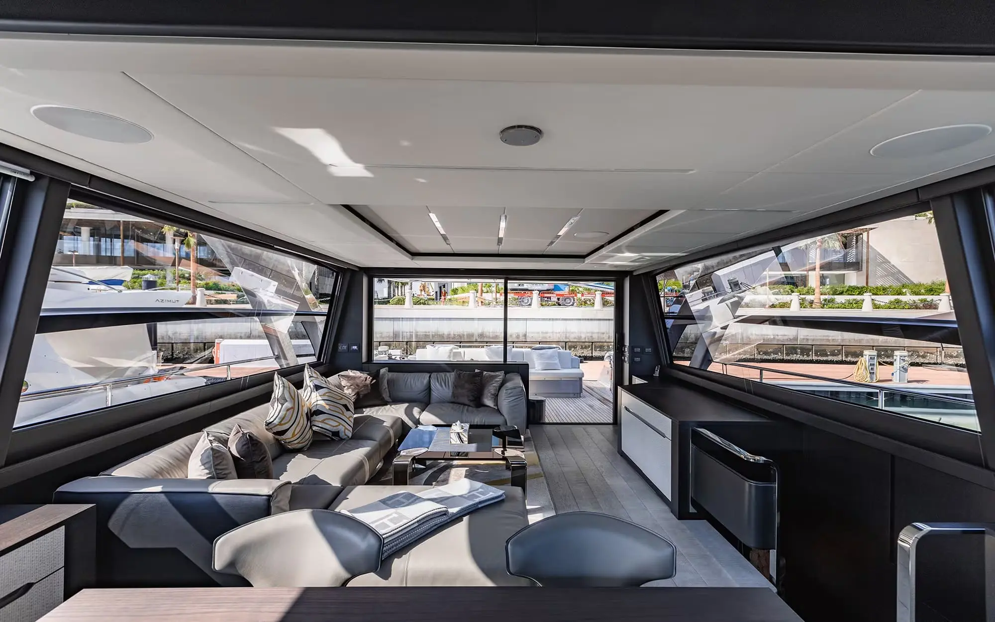 Pershing 8X main saloon lounge with corner sofas in grey tones
