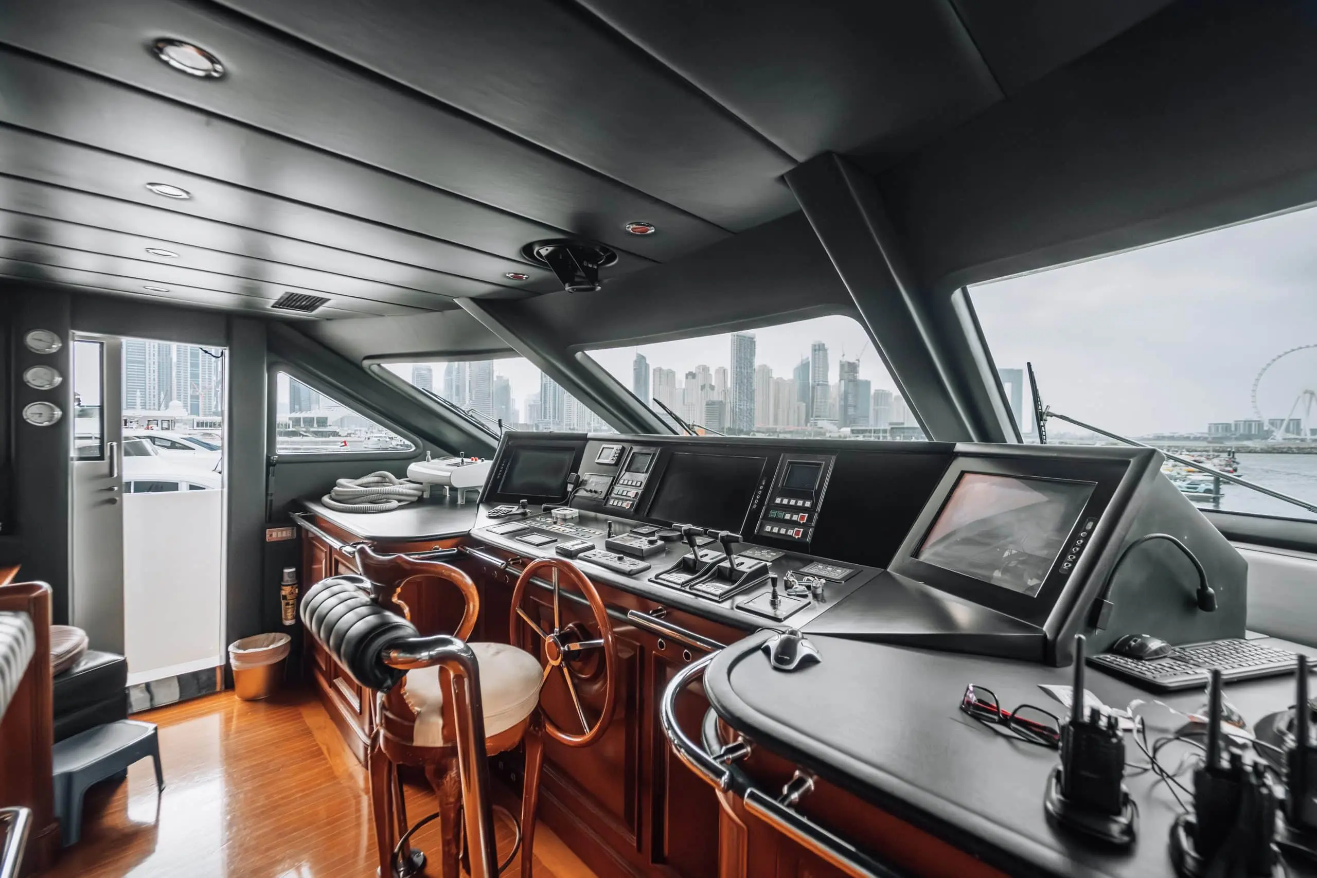 Luxury yacht control room with advanced navigation system and panoramic city skyline view.
