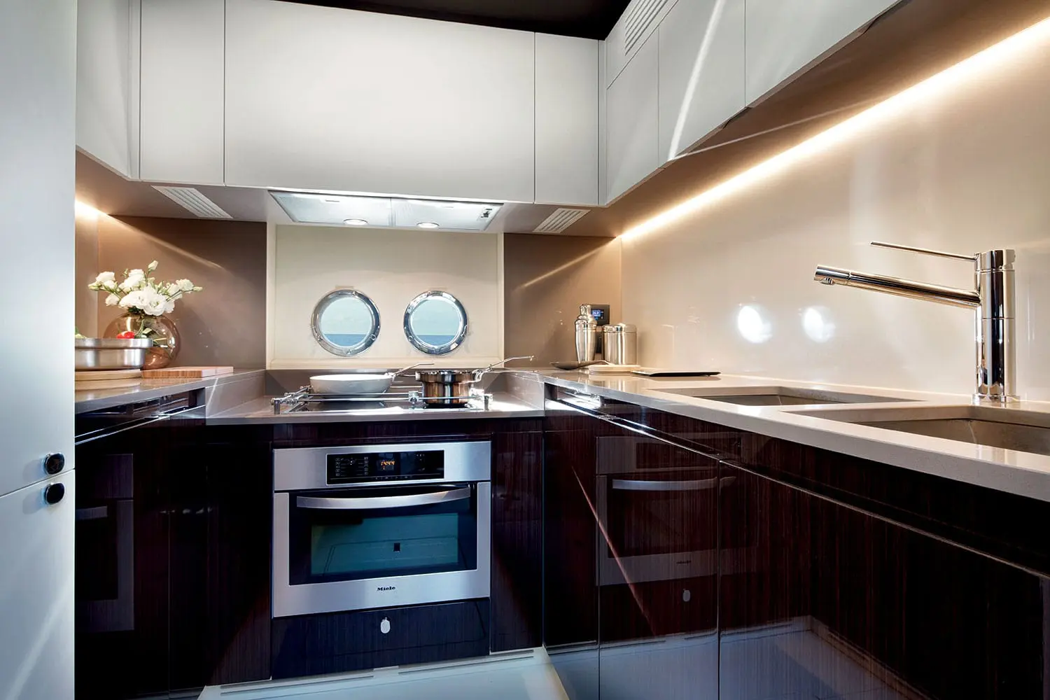 Azimut 77S galley with dark joinery and white worktops — shipyard photo