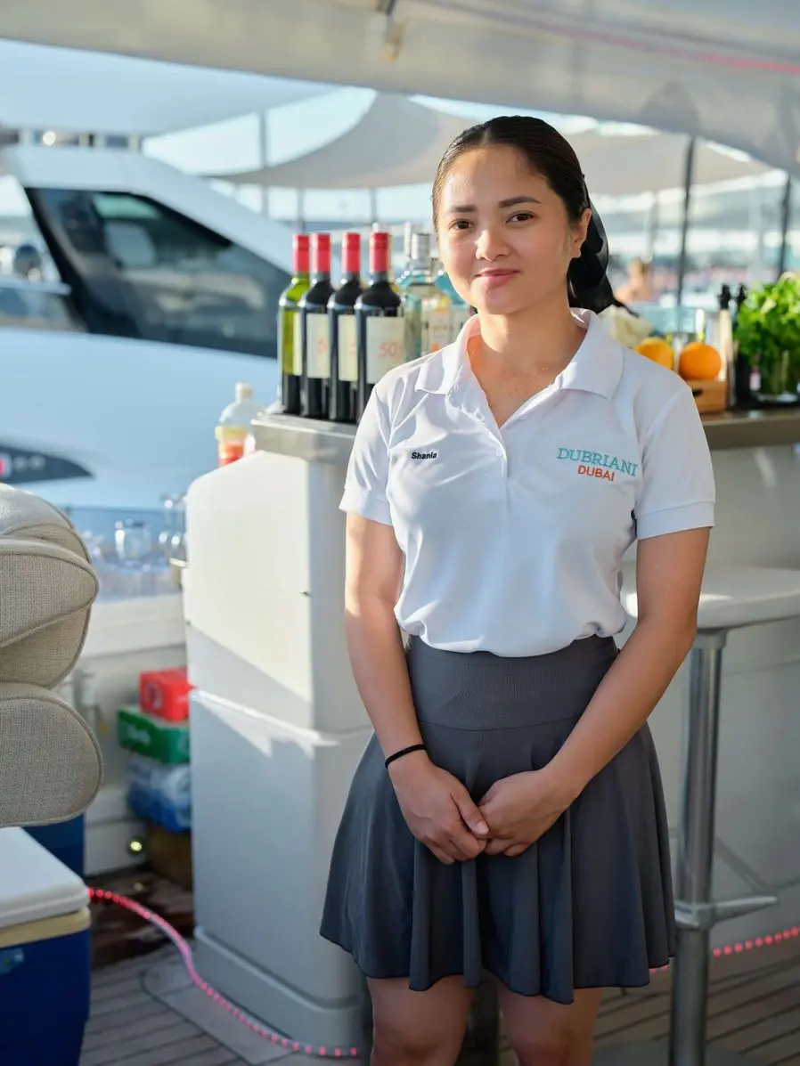 Yacht hostess serving guests onboard during Abu Dhabi Formula 1 yacht charter experience