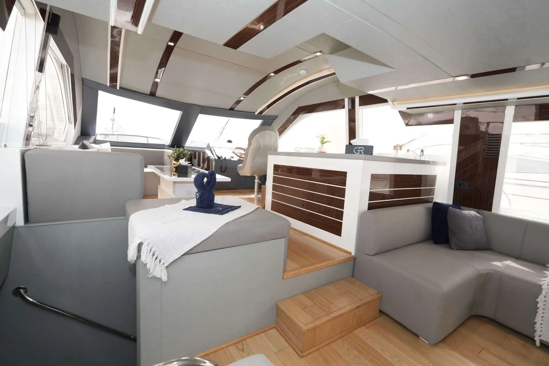 Belle 75 yacht interior with lounge seating and helm station.