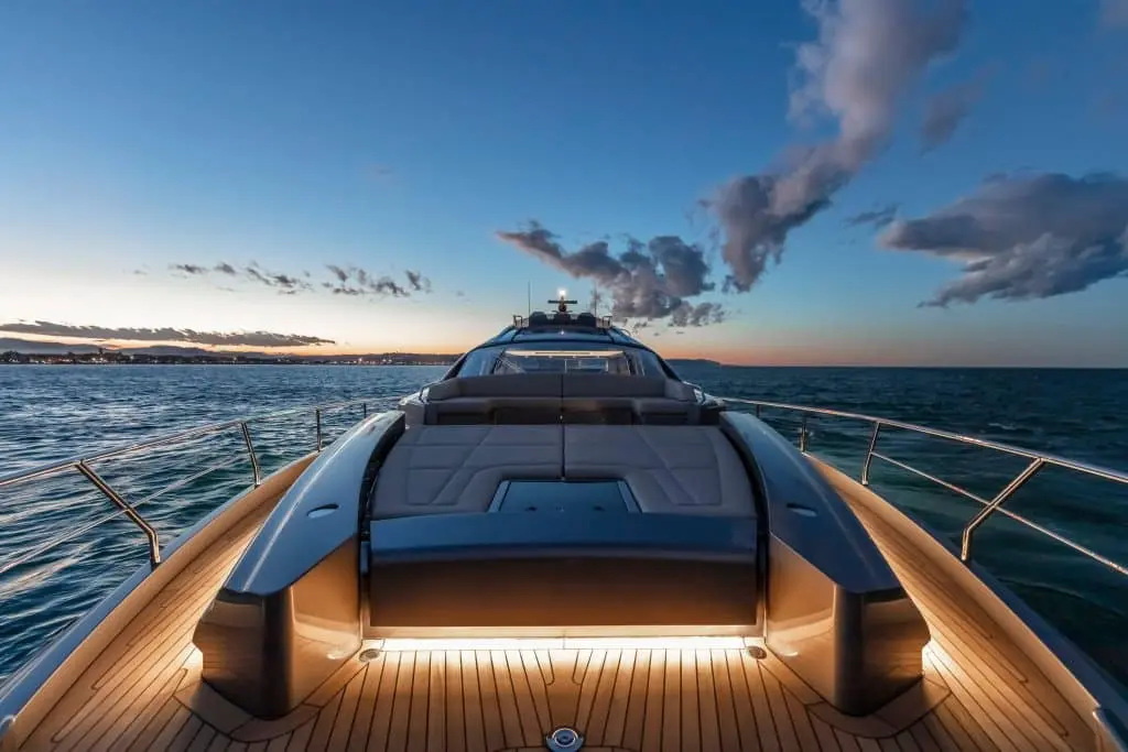 Pershing 8X foredeck sunpad lit at dusk — shipyard photo
