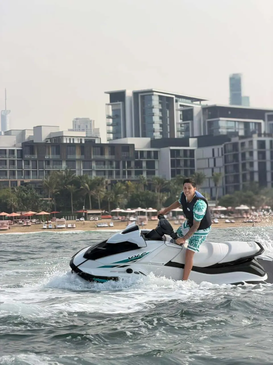 Jet ski rider cruising in Dubai waters with modern buildings in background