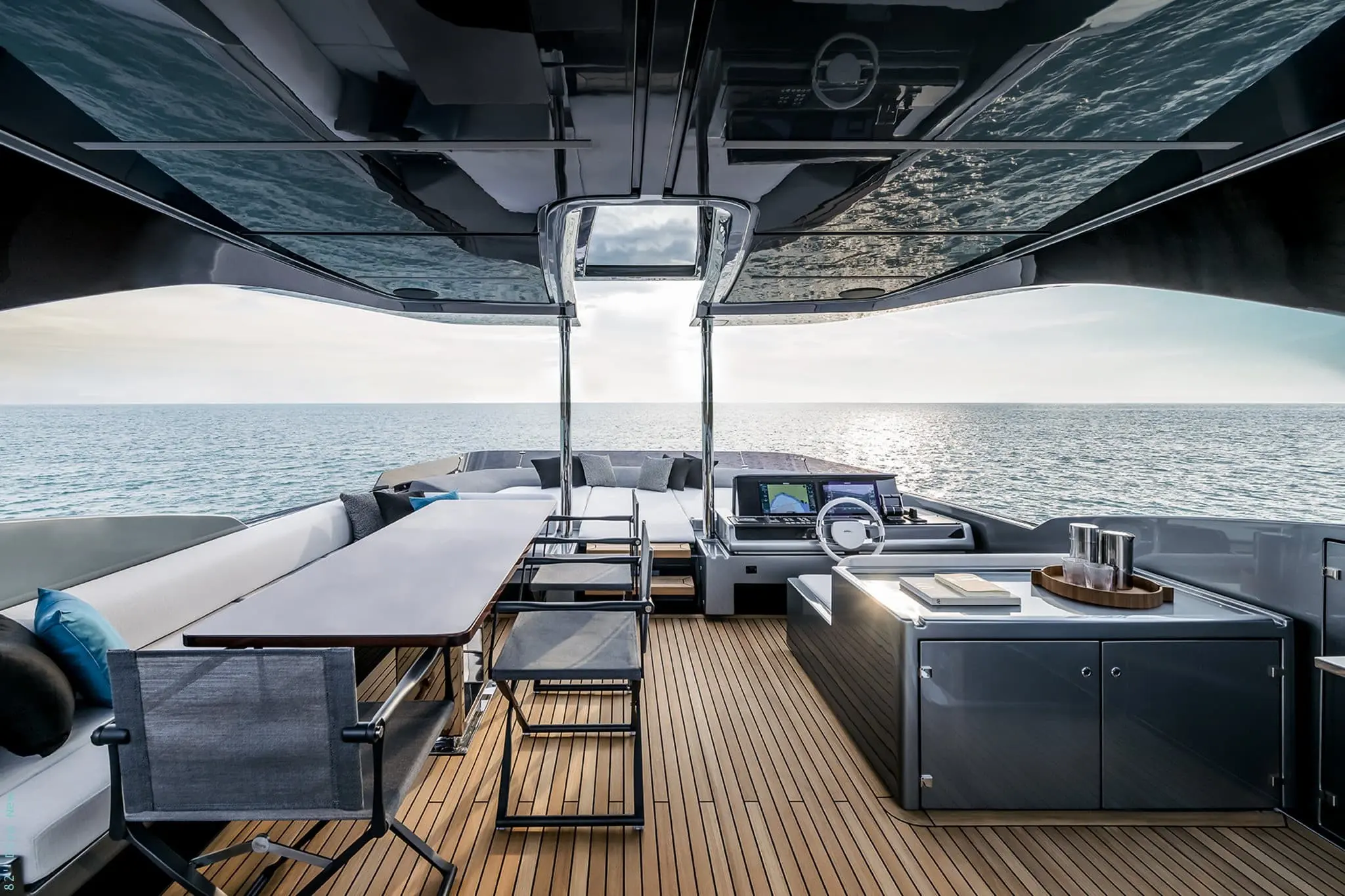 Riva 82 Diva flybridge helm station with dining table and lounge
