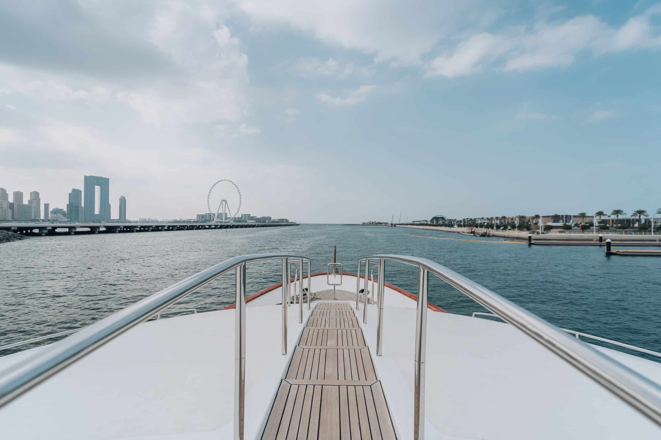 View from yacht bow sailing toward a modern city skyline.