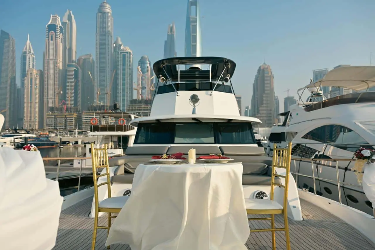 Romantic dining setup on the deck of a Zenith 64 yacht with Dubai Marina skyline in the background
