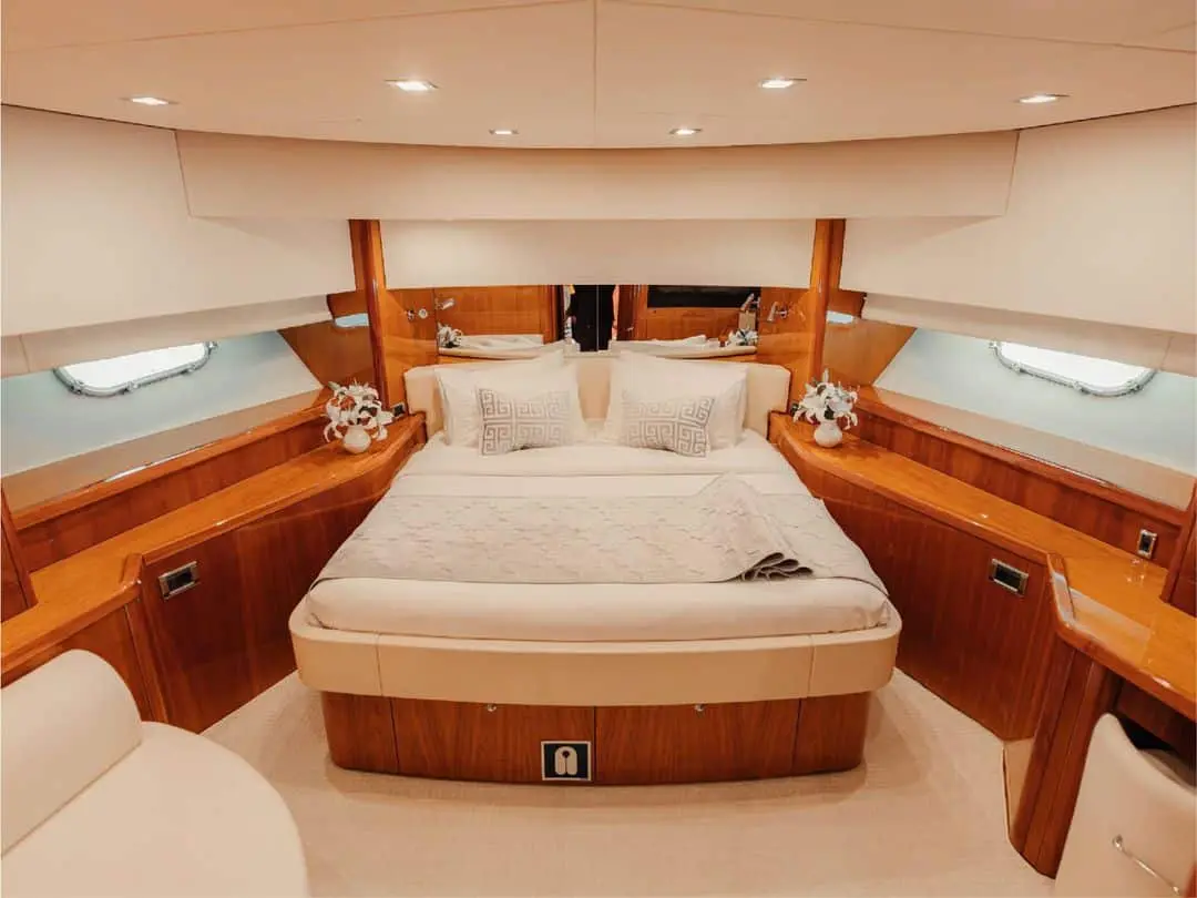 Guest cabin on Notorious yacht with double bed and wooden accents