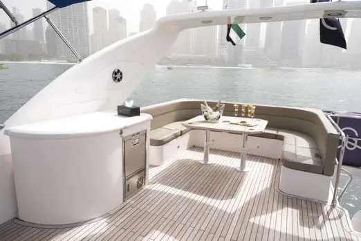 Belle 75 luxury yacht outdoor lounge seating area with table and sea view