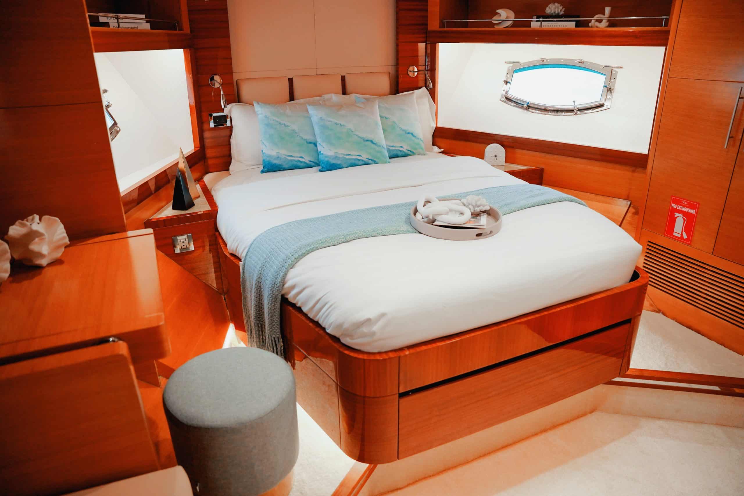 Luxury yacht master bedroom with double bed and wooden interior