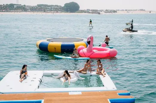 Guests enjoying water activities behind Royalty 136 luxury yacht