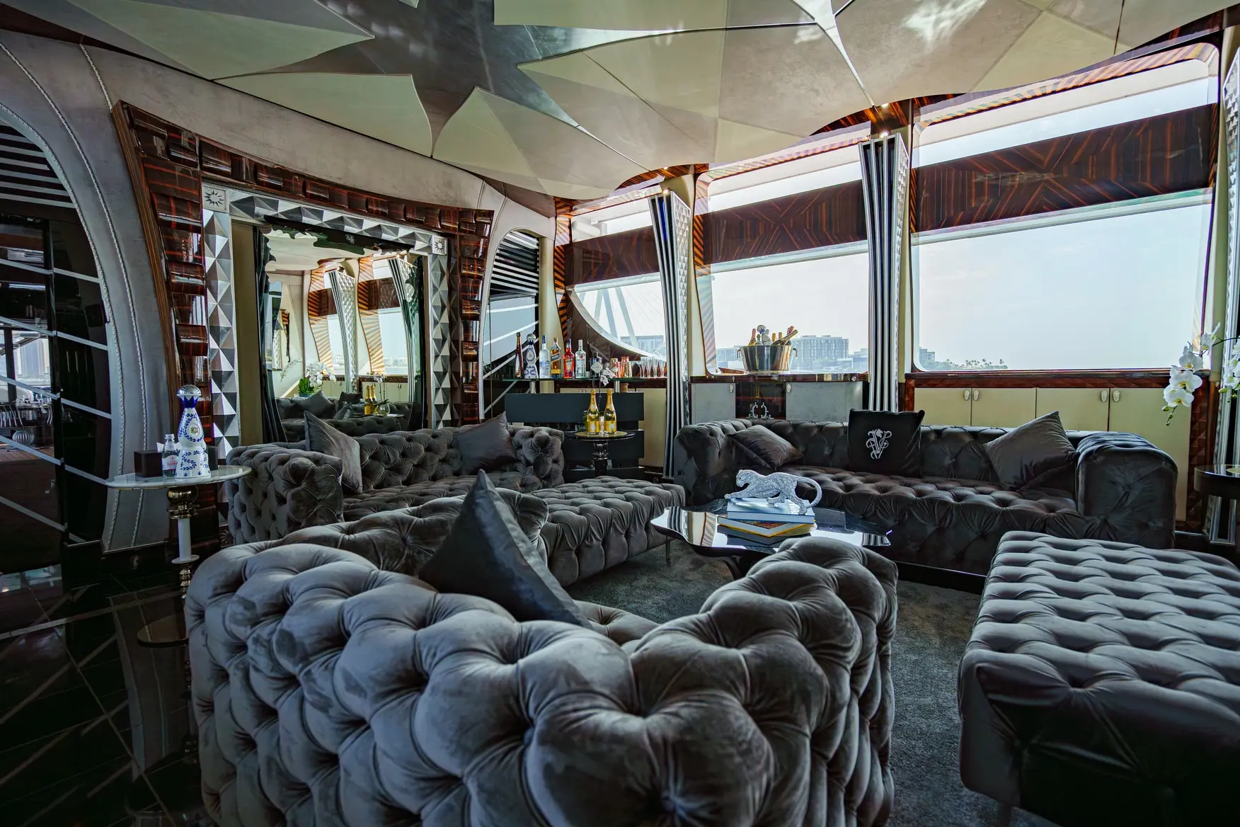 Thunder Superyacht main lounge with tufted sofas and panoramic windows