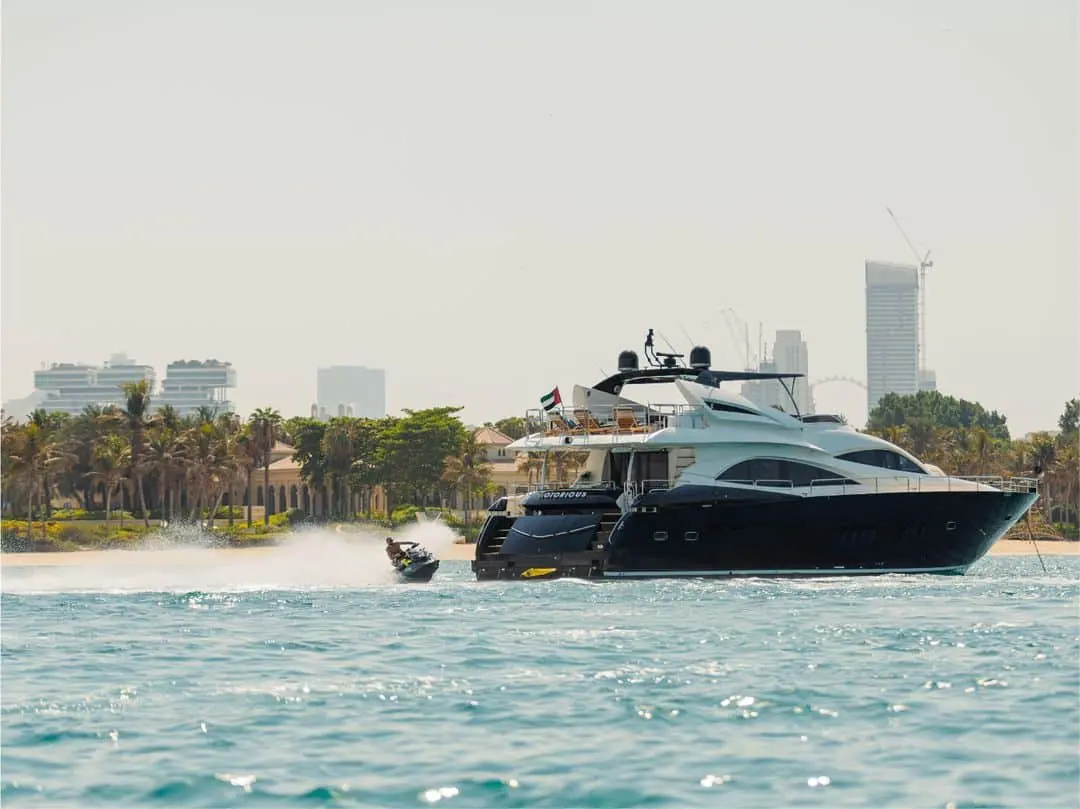 Notorious luxury yacht cruising on open water near the city skyline