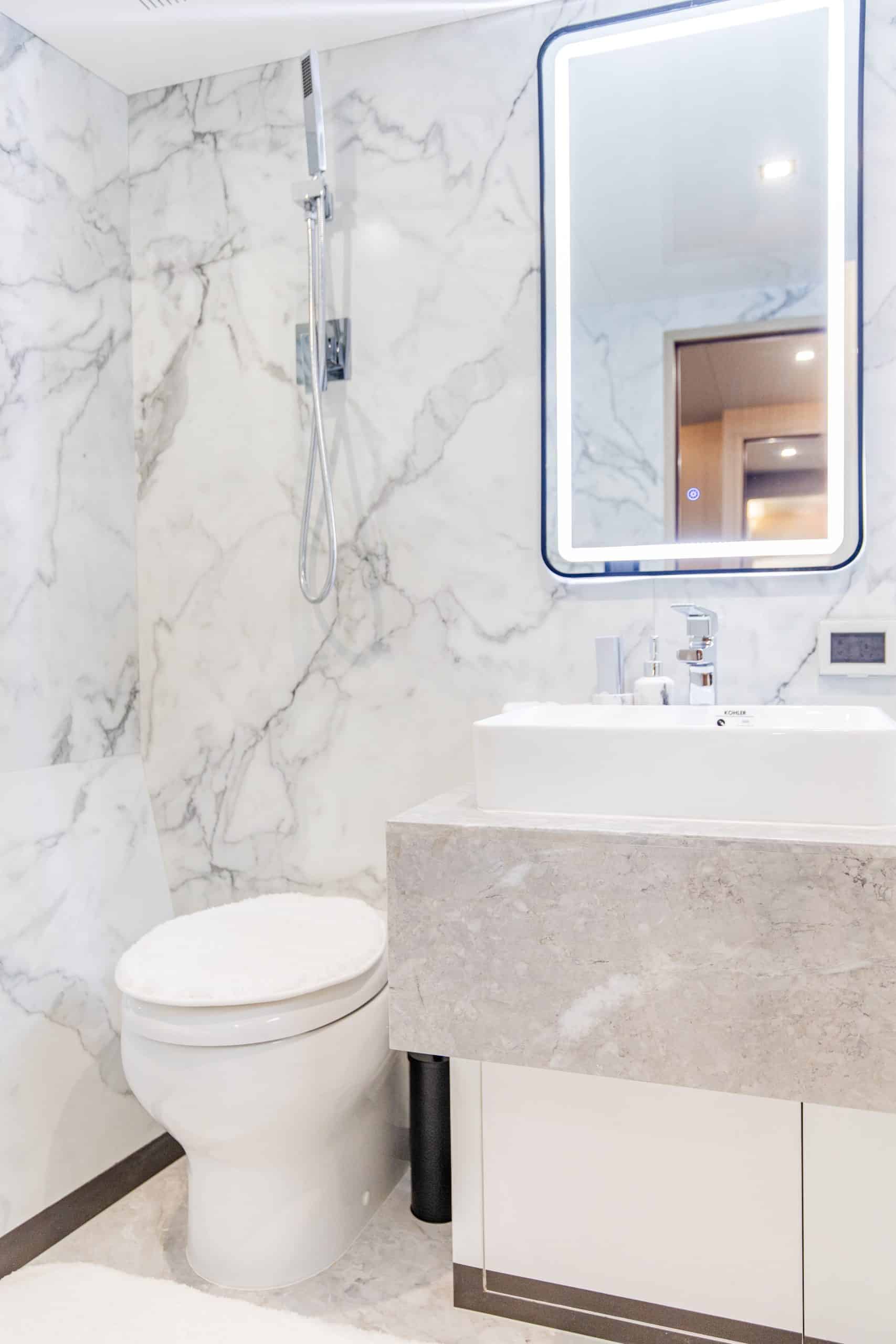 Modern marble bathroom interior of Zirve 72 motor yacht with illuminated mirror
