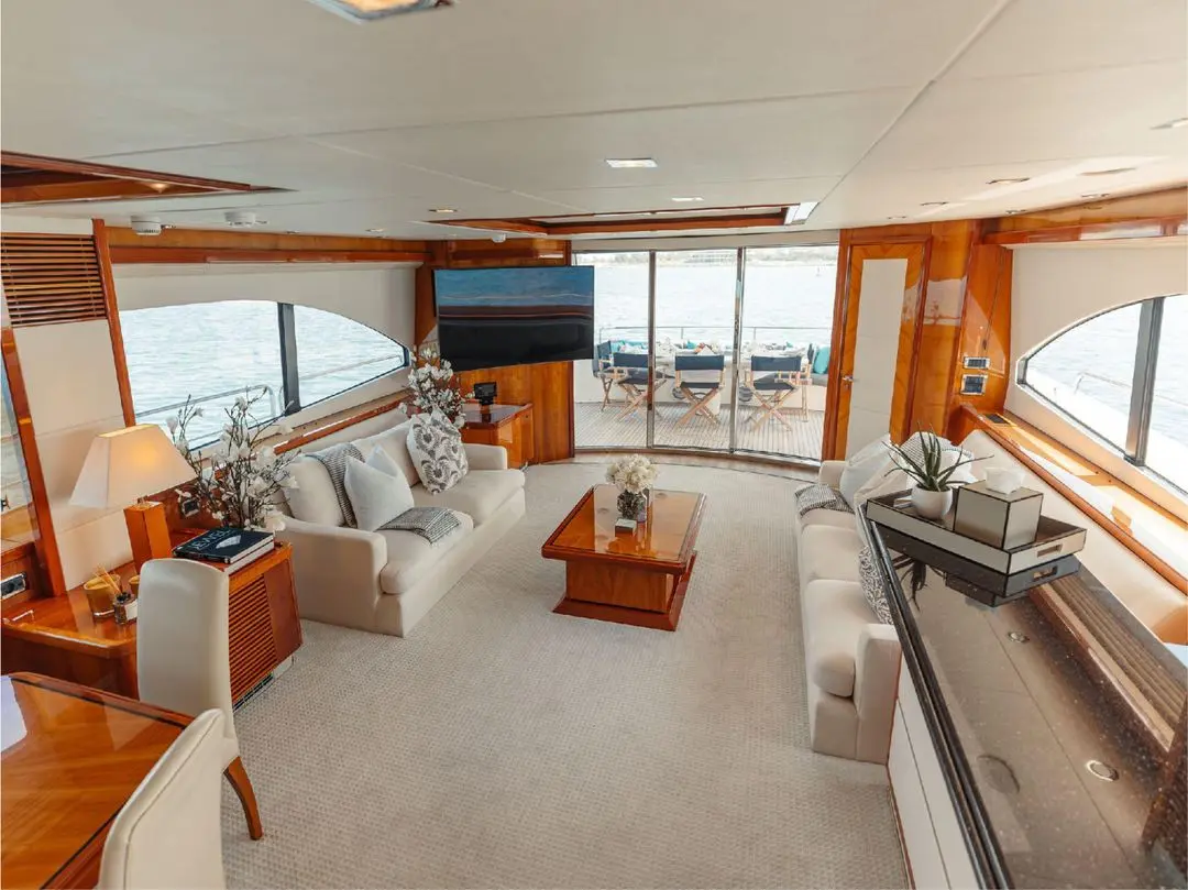 Interior lounge area of Notorious yacht with large windows and modern decor