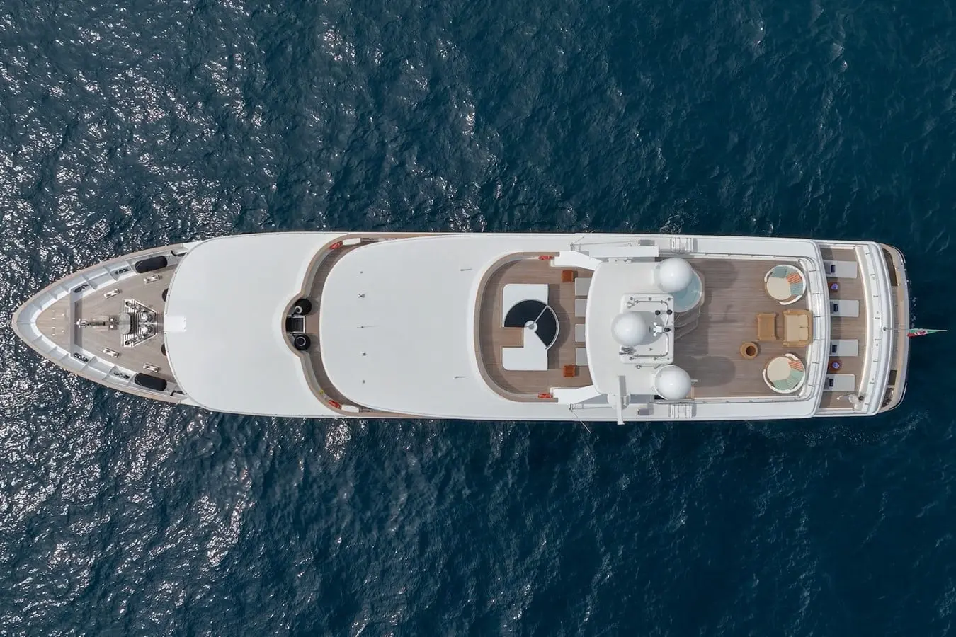 Overhead aerial view of the white 54m Baglietto superyacht at anchor on deep blue open water