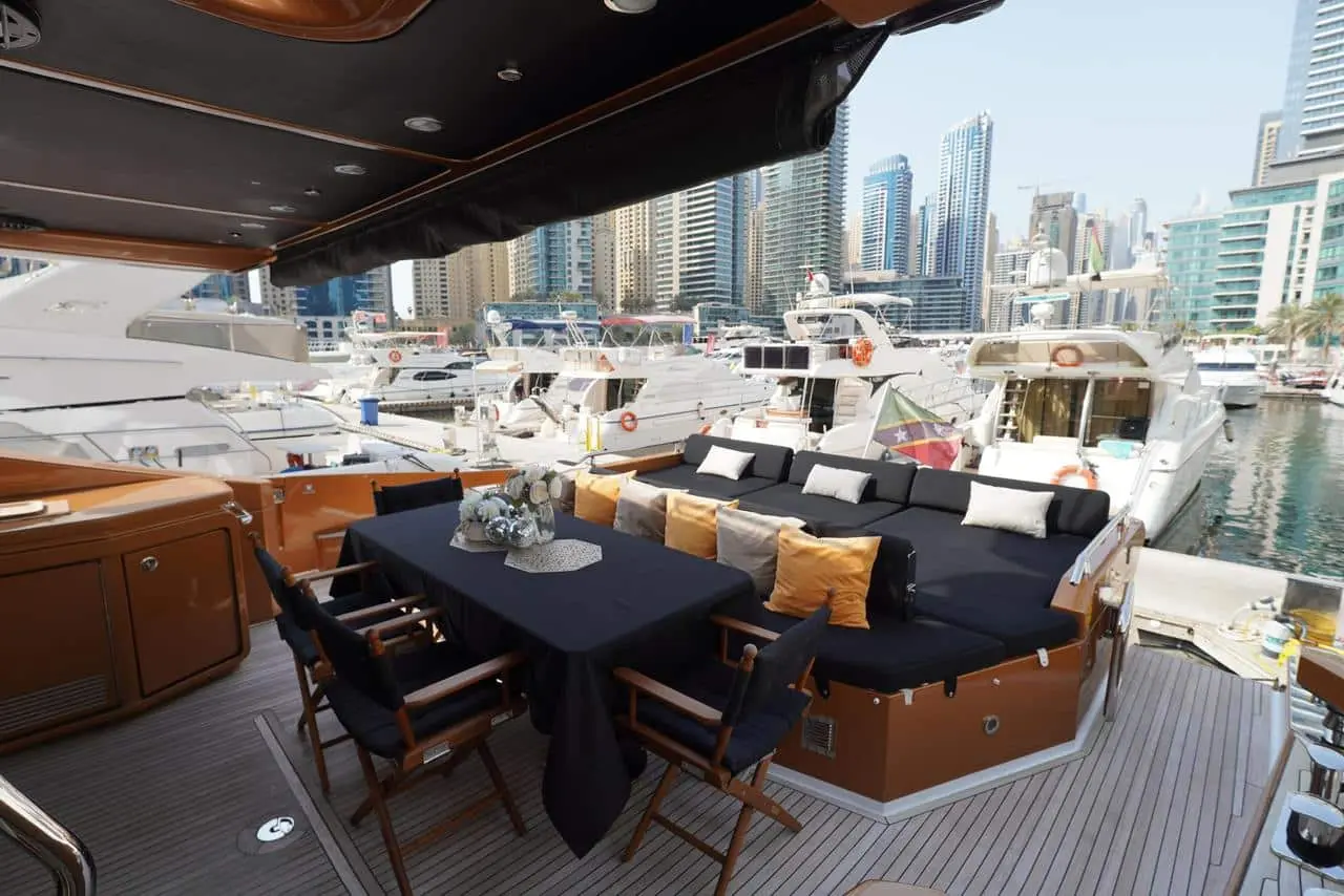 Azimut 77 yacht aft deck dining area with marina skyline view