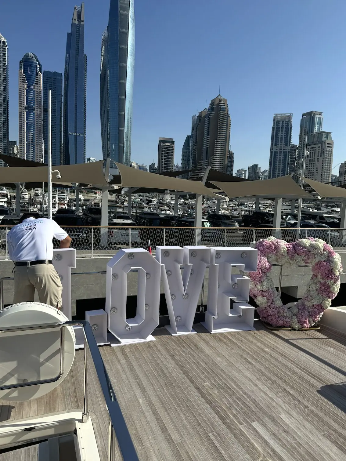 LOVE sign decoration on yacht deck with Dubai skyline background