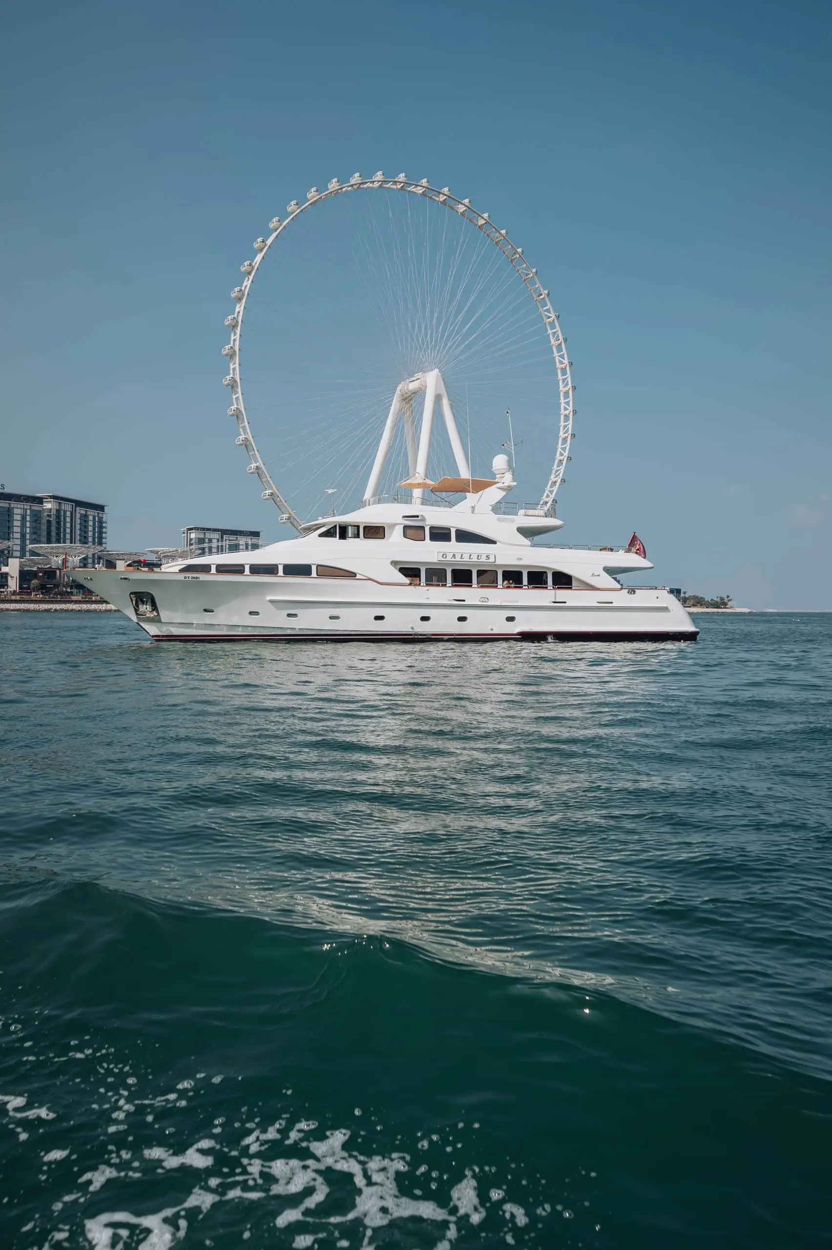 Luxury yacht sailing near giant observation wheel