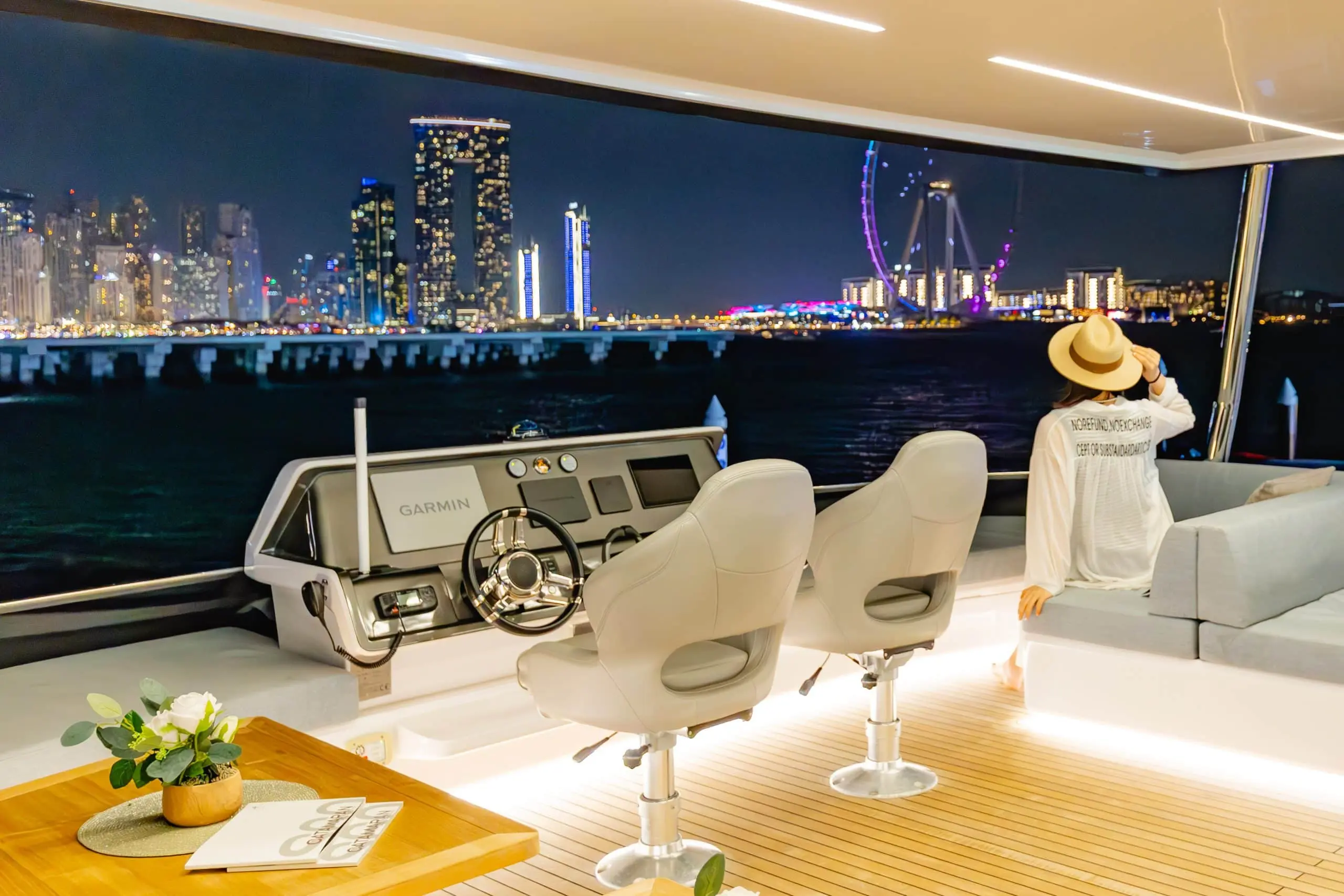 Nighttime skyline view from the Zirve 72 yacht’s front deck with luxury seating