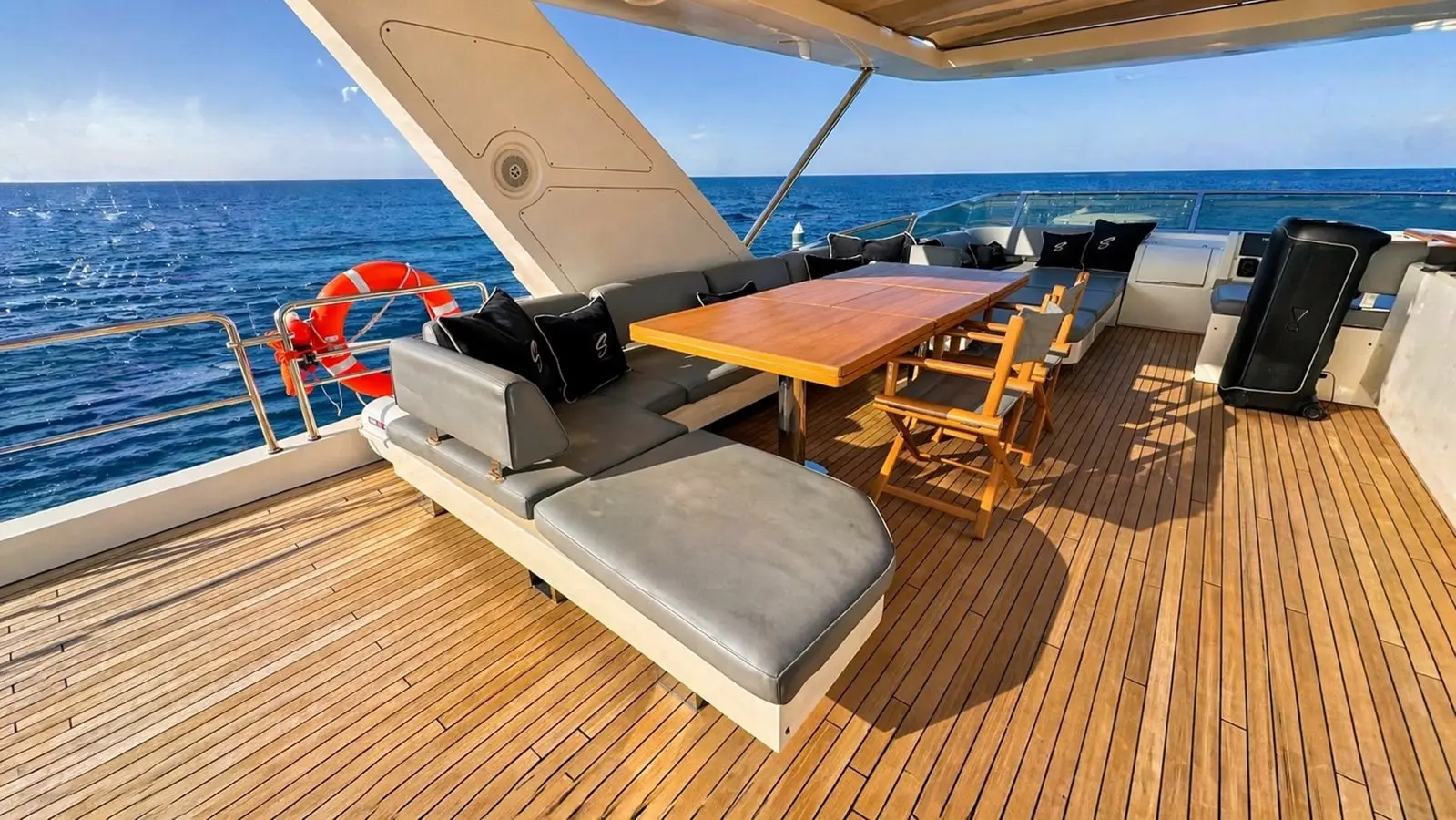 Azimut 88 flybridge lounge with dining table and grey daybed