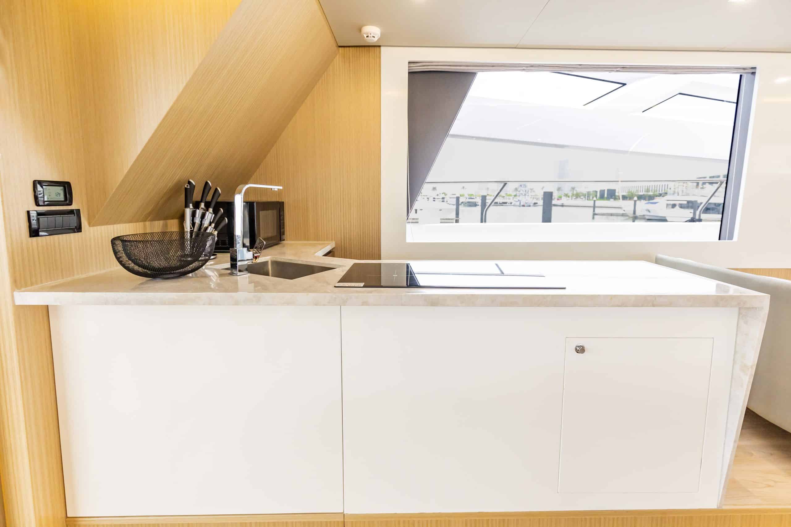 Zirve 72 yacht modern galley kitchen with sleek cabinetry and ocean view window