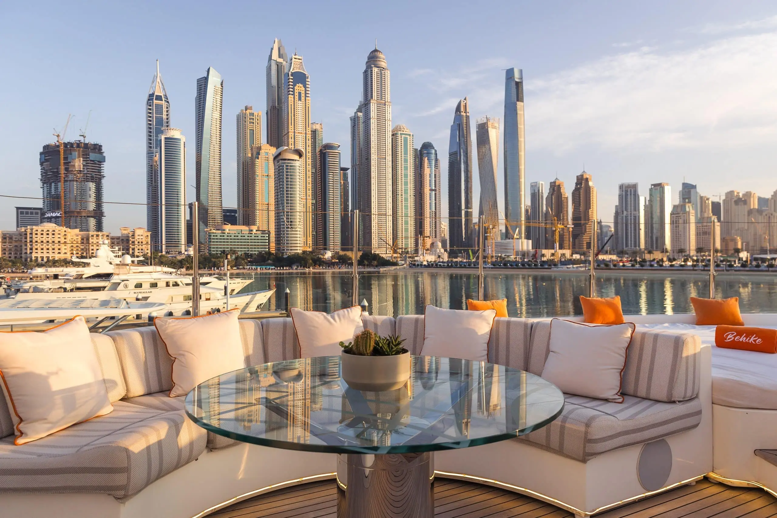 Outdoor dining table on MILA 141 yacht overlooking Abu Dhabi skyline