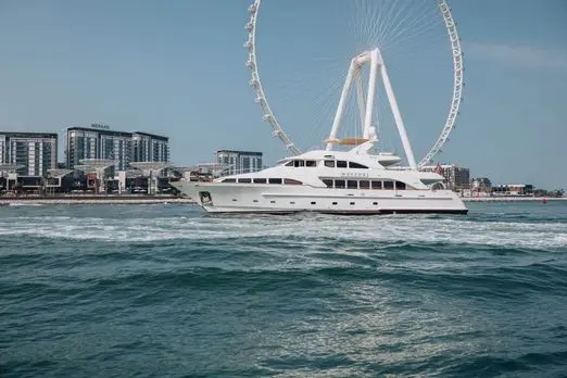 Luxury yacht cruising past Ain Dubai in Dubai.