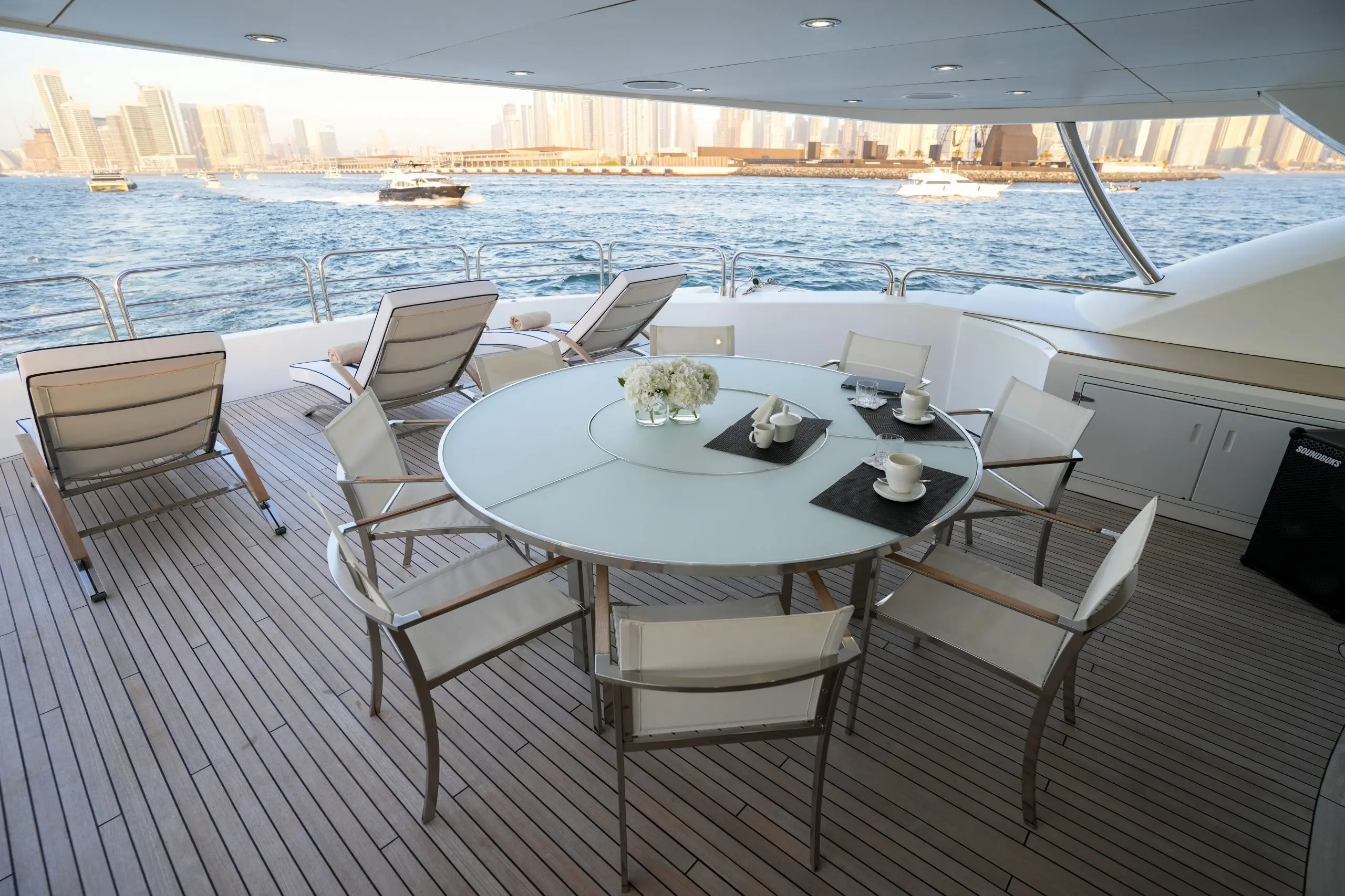 Large round dining table on Sunseeker 131 yacht deck with skyline backdrop