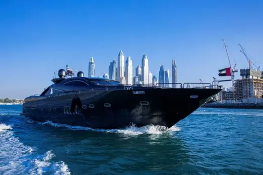 Black Predator 95 Sunseeker yacht cruising bow view with Dubai skyline