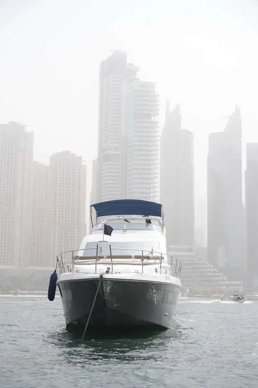 Belle 75 luxury yacht front view on the water with city skyline backdrop