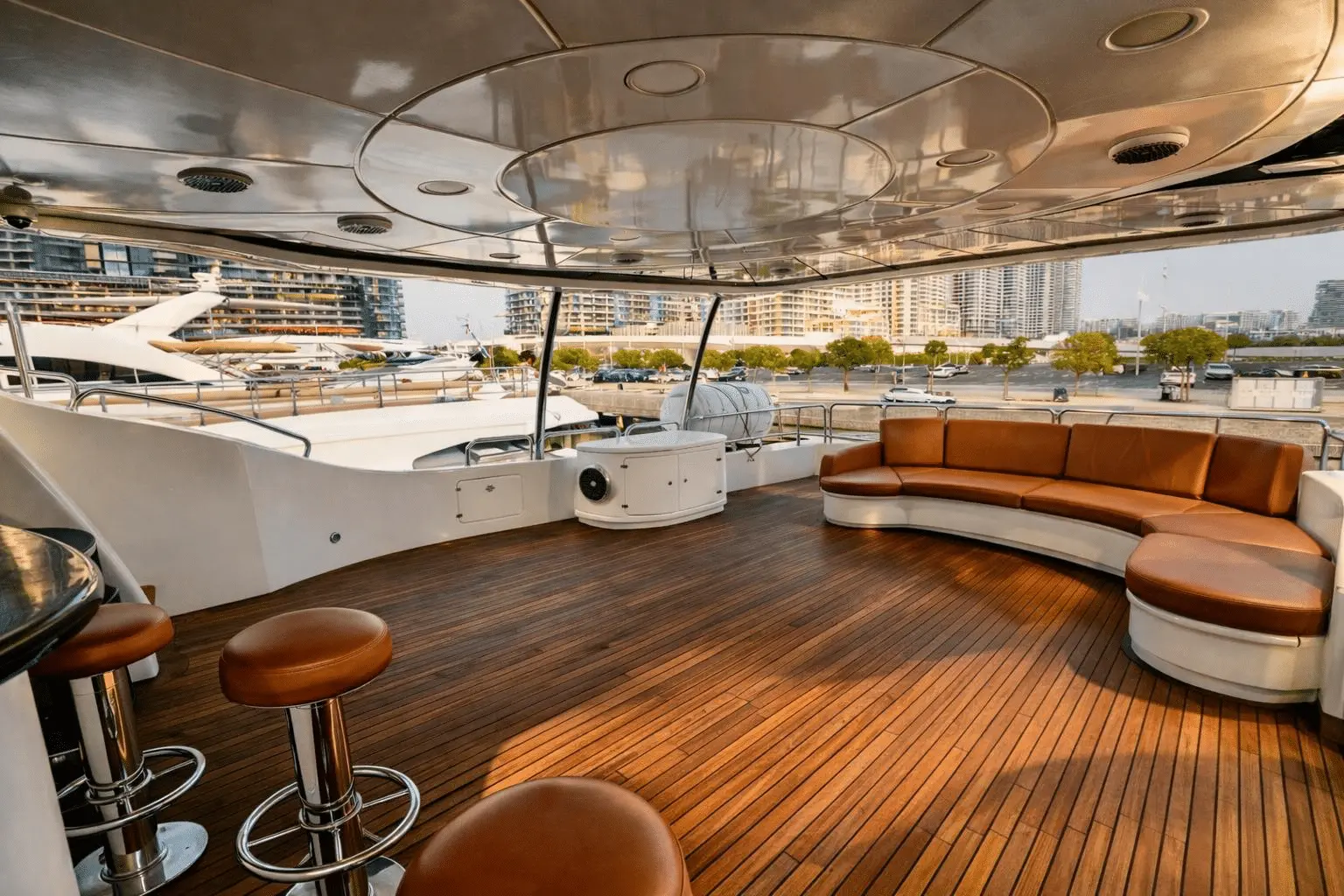 Benetti 120 upper deck lounge with teak flooring and curved sofa seating