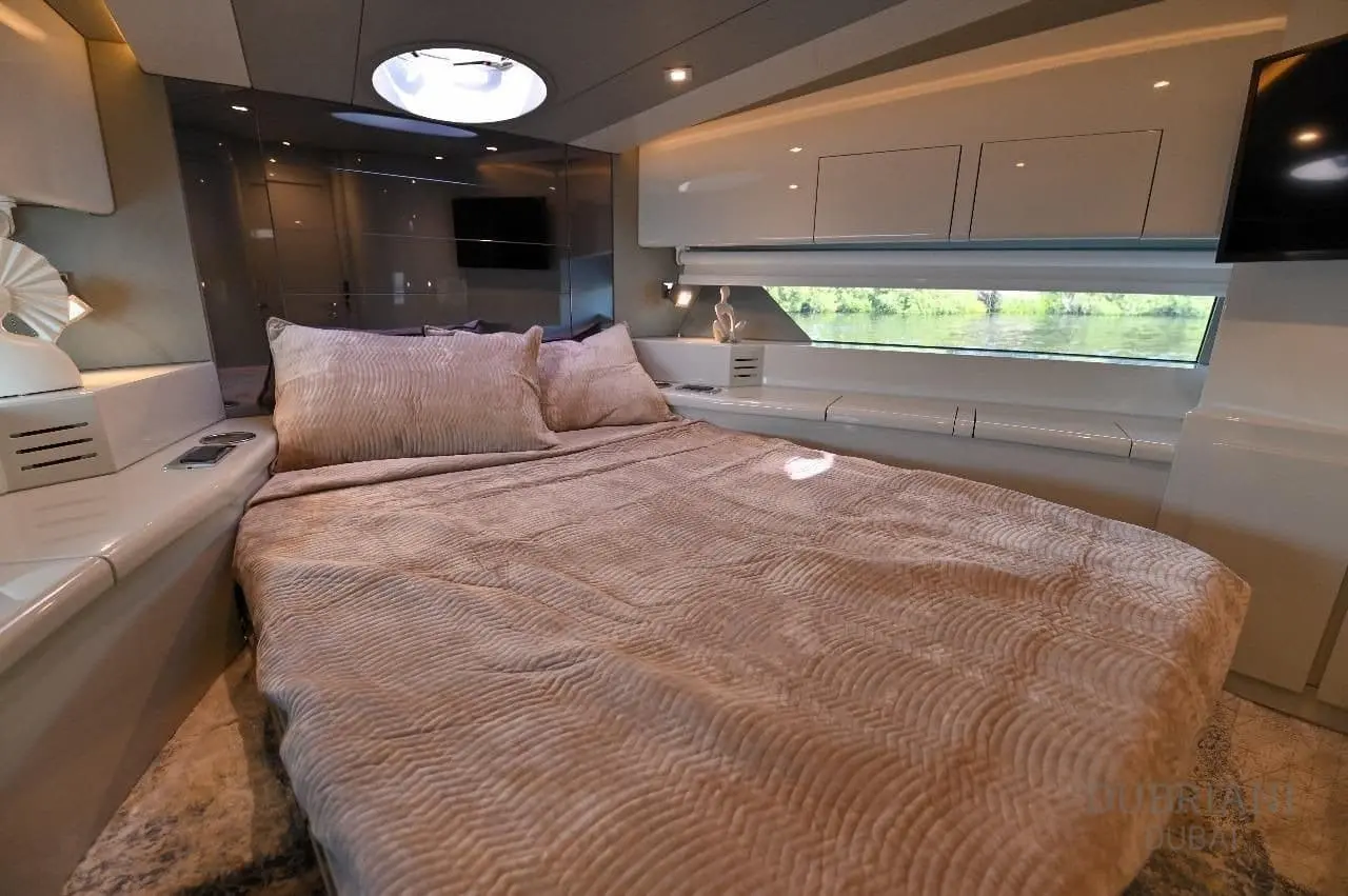 Novia 55 cabin with a double bed in beige linens, overhead hatch, gloss lockers and hull window
