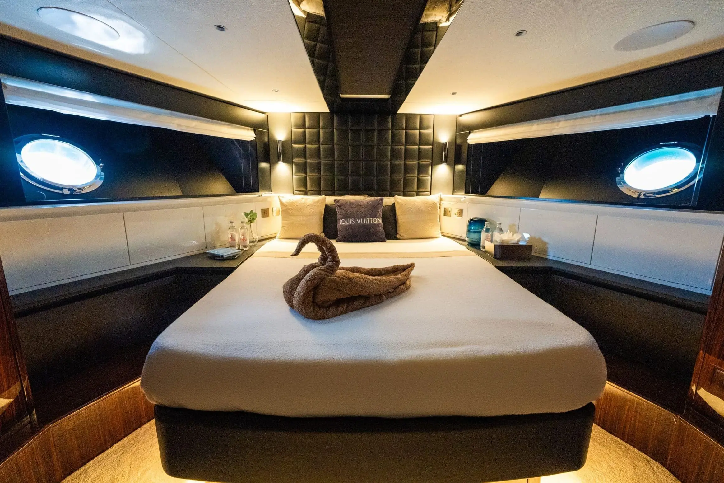 Luxury yacht master cabin with central bed and porthole windows