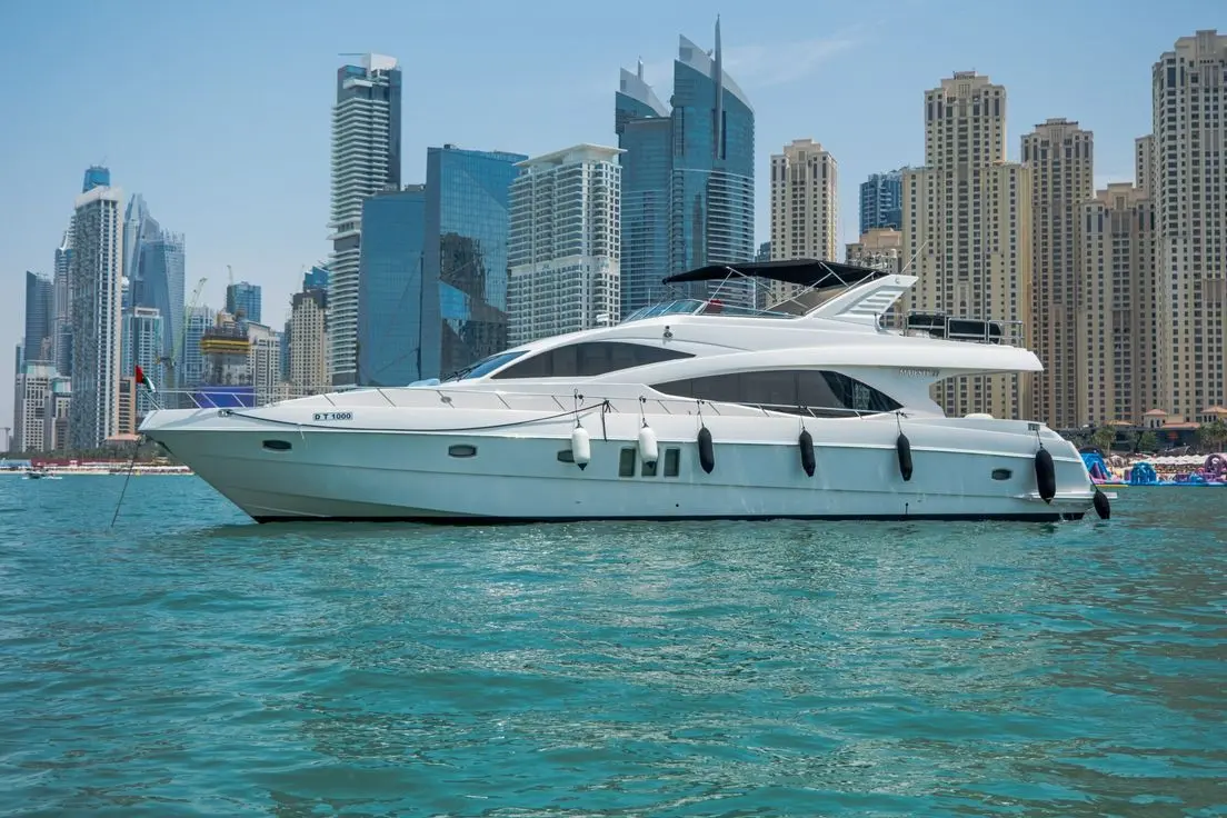 Cabo 77 yacht cruising in Dubai waters with skyline view