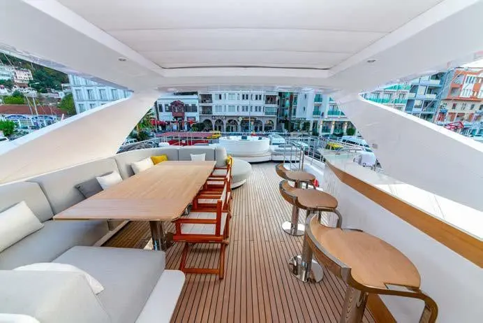 Azimut Grande 27M flybridge dining table and bar under the hardtop, broker photo