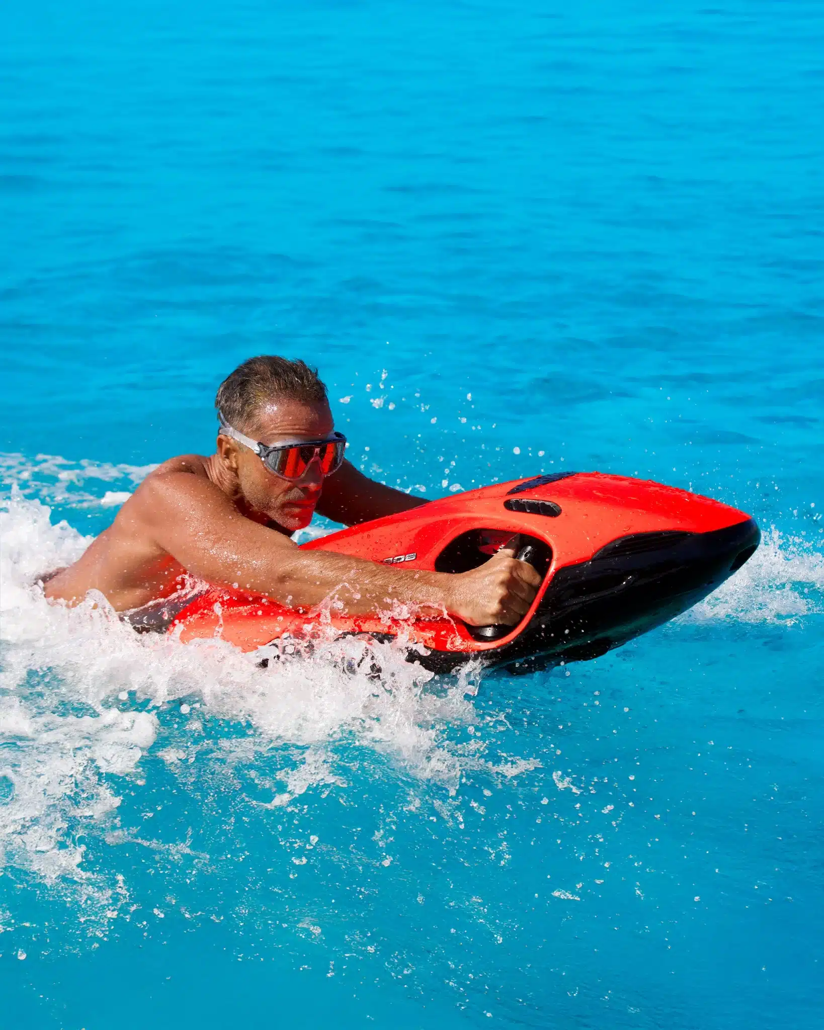 Person riding a red Seabob water scooter on the ocean surface