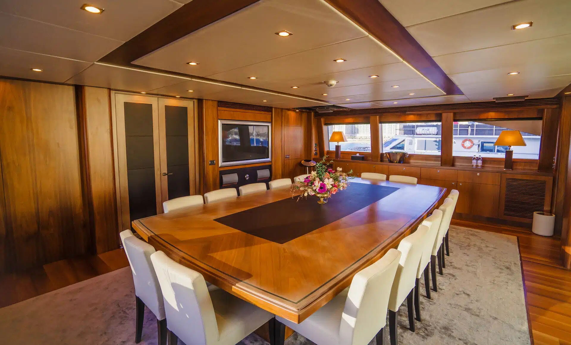 Luxury dining table setup inside Sunseeker 131 yacht with polished wood finish
