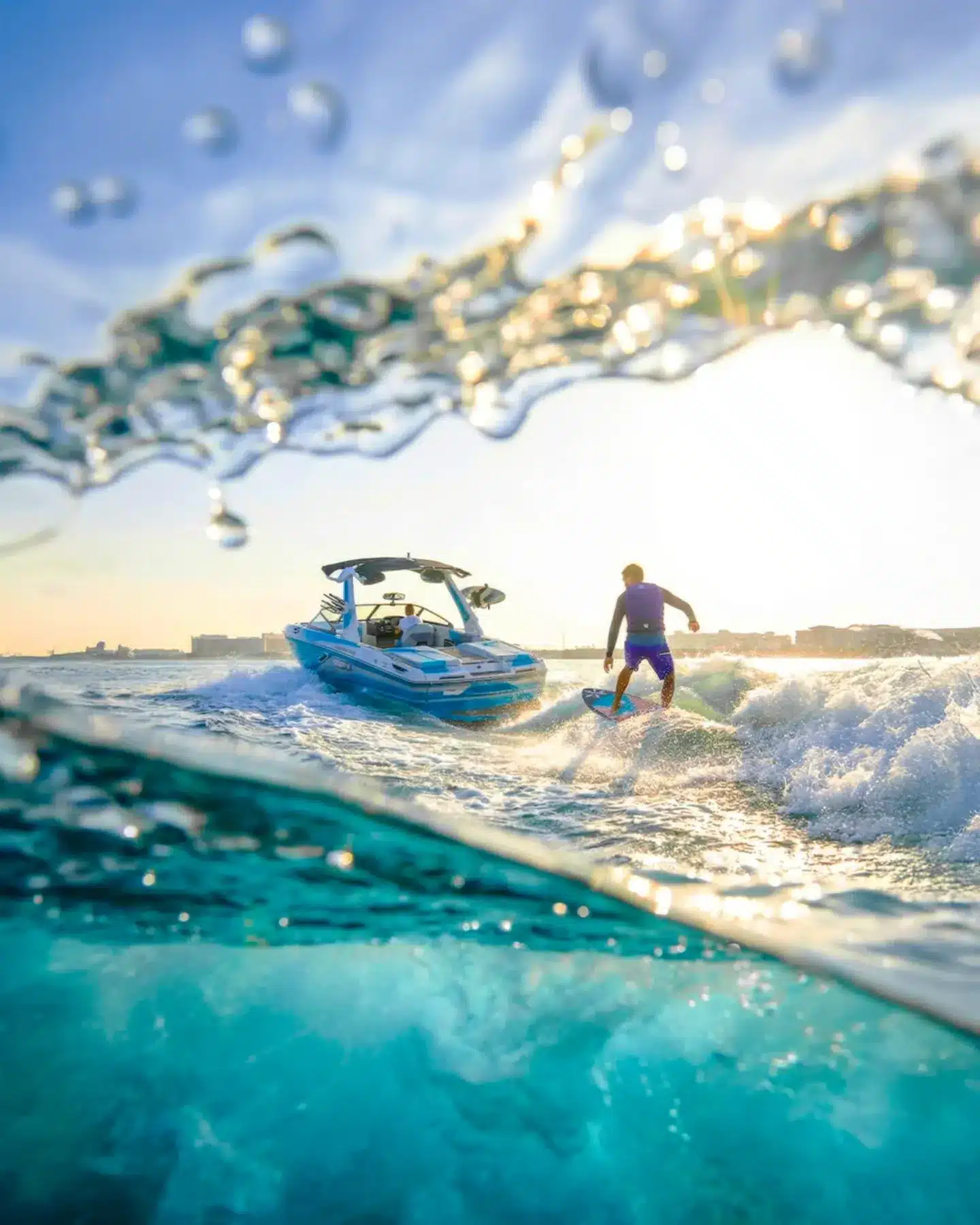 Wakesurfer carving the wave behind a boat at golden hour in Dubai