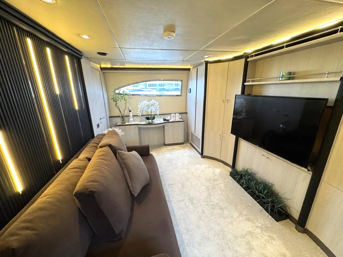 Azimut 100 Jumbo master cabin lounge area with a television