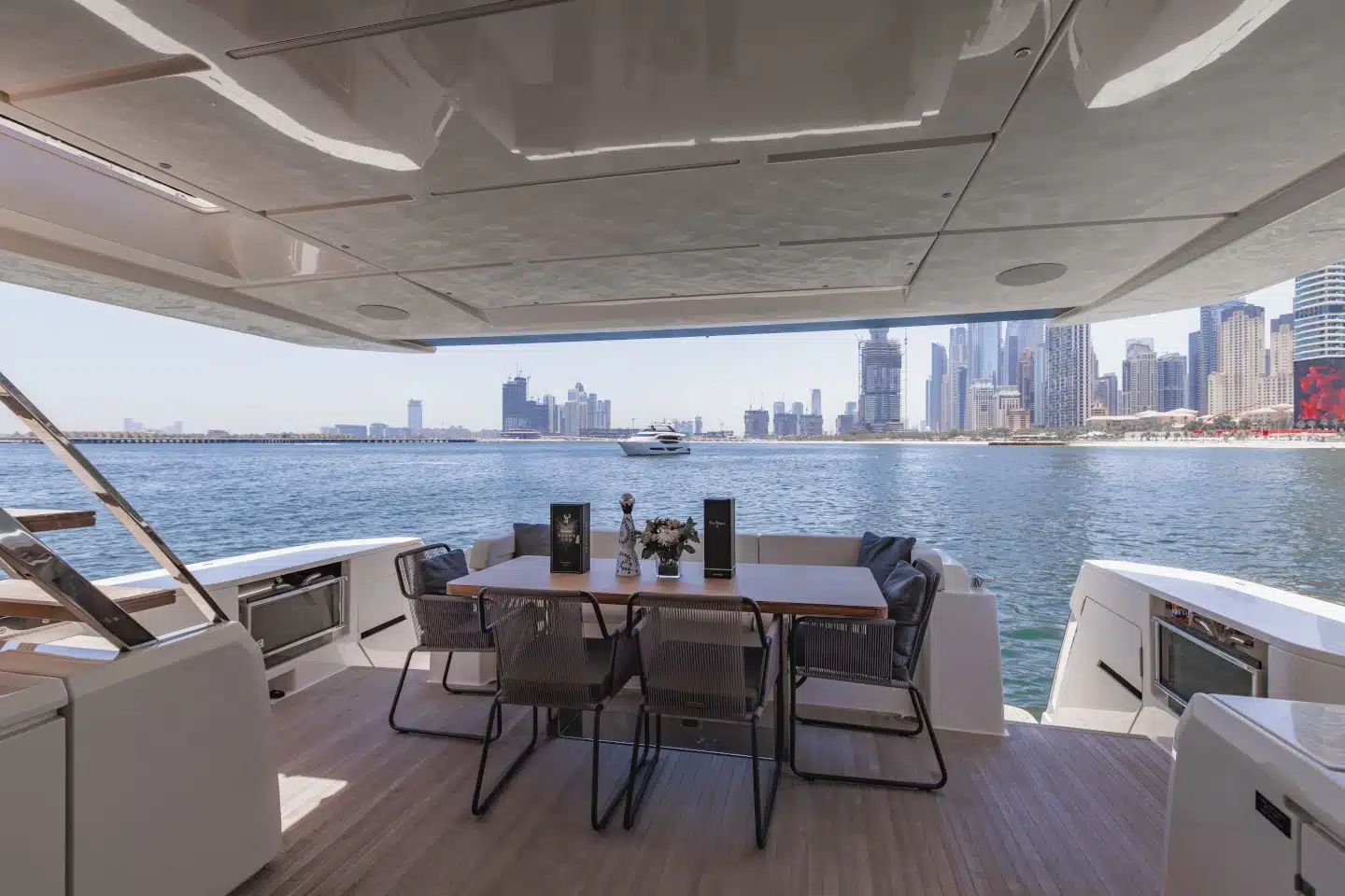 Ferretti 780 aft cockpit dining table with teak deck and Dubai Marina view