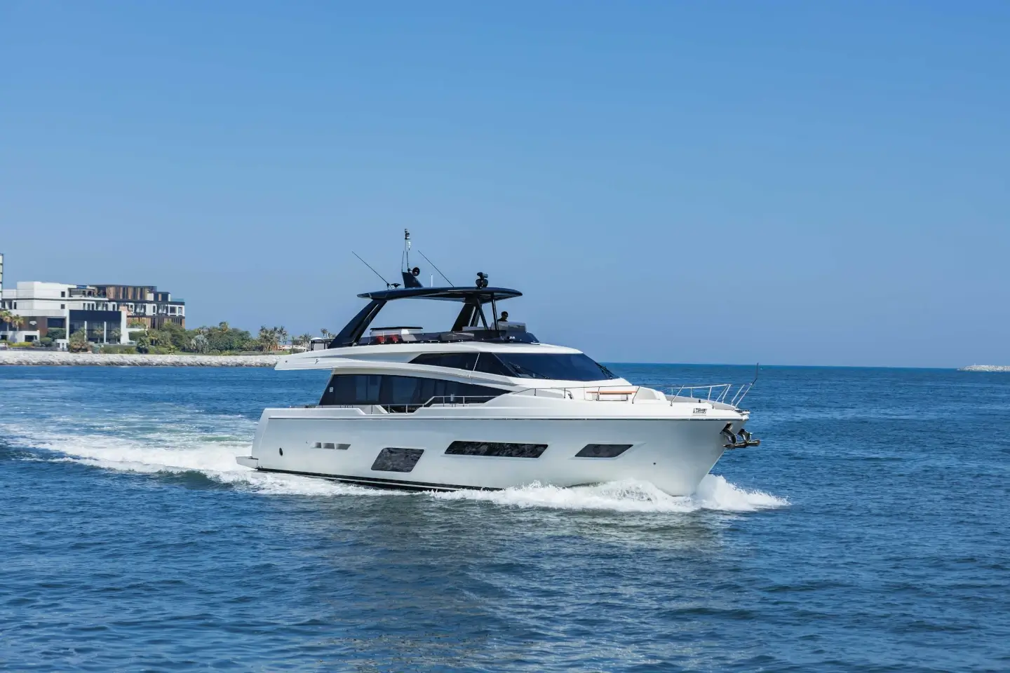 Ferretti 780 cruising at speed with the Dubai coastline behind